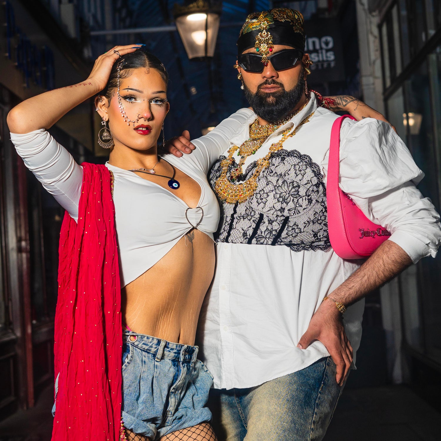 Alia and Muz pose in a dimply lit Arcade.