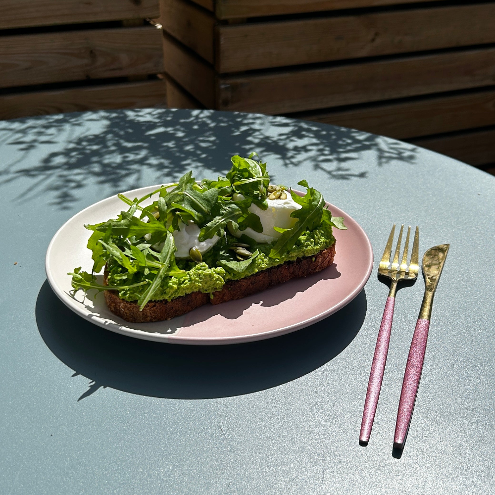 On a pale blue table sits a pink plate, 